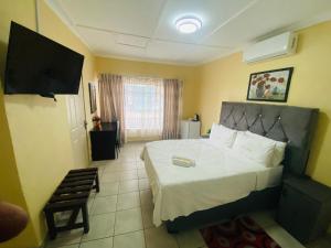 une chambre avec un grand lit et une télévision dans l'établissement Lalamnandzi 4, à White River