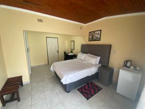 une chambre avec un lit et un plafond en bois dans l'établissement Lalamnandzi 4, à White River 29 autres photos