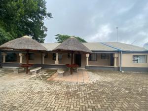 un bâtiment avec deux toits de chaume et un patio dans l'établissement Lalamnandzi 4, à White River