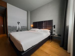 a bedroom with a large bed and a large window at Point Hotel in Piove di Sacco