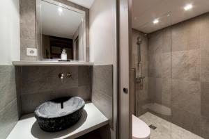 a bathroom with a stone sink and a shower at Le Petit Change - Fully equipped studio in Lyon in Lyon