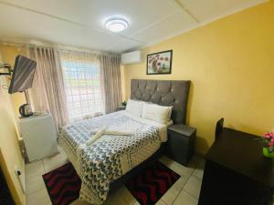 - une petite chambre avec un lit et une grande fenêtre dans l'établissement Lalamnandzi 4, à White River