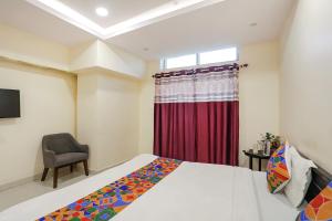 a bedroom with a bed and a red curtain at FabExpress Girija Inn in Nagpur