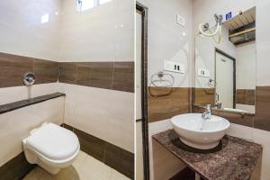 a bathroom with a toilet and a sink and a shower at FabExpress Girija Inn in Nagpur