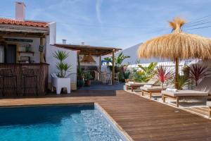 uma villa com uma piscina e um deque de madeira em Casa Idalia Boutique Hotel em Comporta