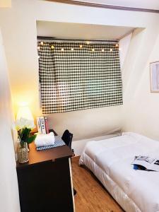 Schlafzimmer mit einem Bett, einem Schreibtisch und einem Fenster in der Unterkunft NineRoD - Private bathroom & Shower in Seoul