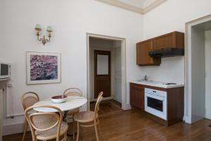 a kitchen with a table and chairs and a table and a table and a kitchen at Enjoy Residencé Château de Monbrison, apartment for two guests in Saint-Michel