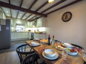a kitchen with a wooden table with plates and wine glasses at Bryndalis Ciliau Aeron in Ciliau-Aeron