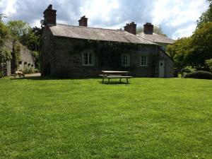 a picnic table in front of a stone house at The Stables Cardigan in Cardigan