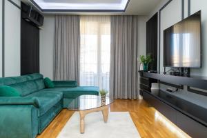 a living room with a green couch and a table at Unity Luxury Apartment - Skopje in Skopje