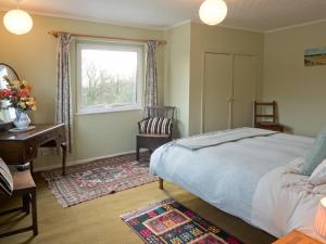 Schlafzimmer mit einem Bett, einem Schreibtisch und einem Fenster in der Unterkunft Ffynnonddewi Llandygwydd in Cenarth