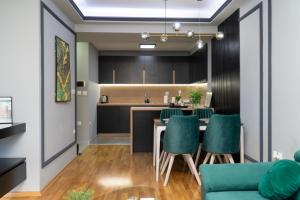 a kitchen and dining room with a table and green chairs at Unity Luxury Apartment - Skopje in Skopje