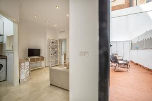 an open living room with a couch and a television at Apto Omeya & Center & Parking in Córdoba