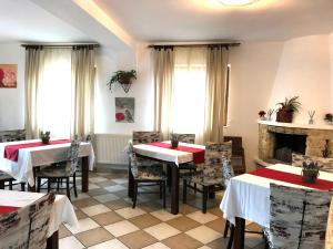 ブシュテニにあるD&D Busteniのテーブルと椅子、暖炉のあるレストラン