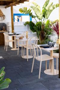 a dining room with white tables and chairs at Casa Idalia Boutique Hotel in Comporta