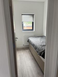 een kleine slaapkamer met een bed en een raam bij Remarkable 3-Bed Apartment in London in Hendon