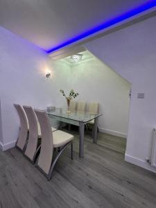 ein Esszimmer mit einem Glastisch und Stühlen in der Unterkunft Impeccable 2-Bed Apartment in London in Hendon