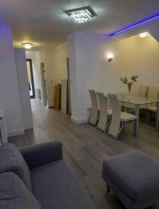 ein Wohnzimmer mit einem Sofa, einem Tisch und Stühlen in der Unterkunft Impeccable 2-Bed Apartment in London in Hendon