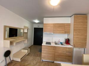 a small kitchen with wooden cabinets and a sink at Apartments Amara Sunny Beach in Sunny Beach