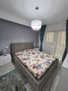 a bedroom with a bed with a floral comforter at Confort Residence in Craiova