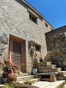 - un bâtiment en pierre avec des escaliers devant dans l'établissement 芹壁梅好石屋 Mayhao Stone House, à Beigan