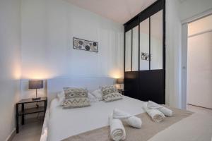 L'Hôtelier - CHU / Bein Sport/Canal + في ميلا: غرفة نوم بيضاء مع سرير أبيض كبير مع الوسائد