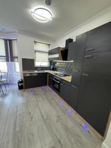 an empty kitchen with blue lights on the floor at Second Av flat 4 Hendon London in Hendon