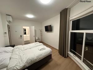 a bedroom with a bed and a large window at Voyagers Amsterdam in Amsterdam