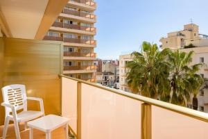 un fauteuil blanc sur un balcon avec vue sur la ville dans l'établissement htop Amaika & SPA 4Sup - Adults Only #htopBliss, à Calella