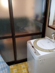 a washing machine in a room with a window at ゲストハウスかもめ in Ishinomaki