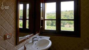 a bathroom with a sink and two windows at Locanda in Vigna in Arzachena