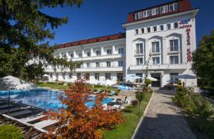 a hotel with a swimming pool in front of a building at Melsa COOP Hotel in Nesebar