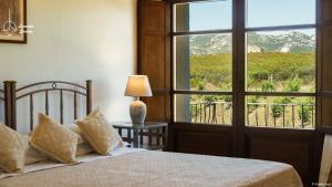 a bedroom with a bed and a large window at Locanda in Vigna in Arzachena