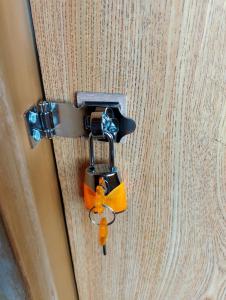a lock on a door with a orange bow on it at ゲストハウスかもめ in Ishinomaki
