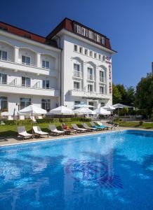 a hotel with a swimming pool in front of a building at Melsa COOP Hotel in Nesebar