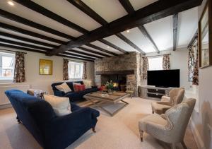 a living room with blue furniture and a stone fireplace at Barton Farm in West Down