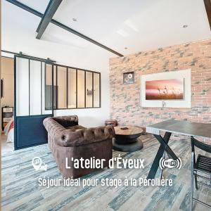 a living room with a couch and a brick wall at L atelier d Eveux in Éveux
