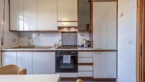 La cuisine est équipée de placards blancs et d'un four avec plaques de cuisson. dans l'établissement Casa Pucci - Affitti Brevi Italia, à Modène
