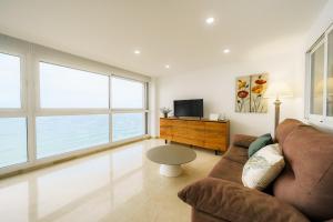 ein Wohnzimmer mit einem Sofa und einem TV in der Unterkunft Santa Margarita - Benisun in Benidorm