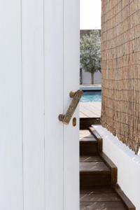 uma porta de madeira com uma maçaneta de madeira ao lado de uma piscina em Casa Idalia Boutique Hotel na Comporta