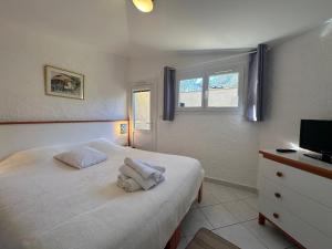 um quarto com uma cama com duas toalhas em LBV Les Bastidons de Villepey em Saint-Aygulf