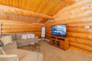 a living room with a couch and a television in a cabin at Tucked Away Timbers in Fairbanks