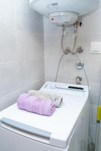 Baño blanco con una toalla rosa en la encimera en Unity Luxury Apartment - Skopje en Skopje