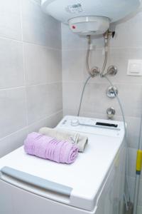 a white bathroom with a pink towel on a counter at Unity Luxury Apartment - Skopje in Skopje +26 photos
