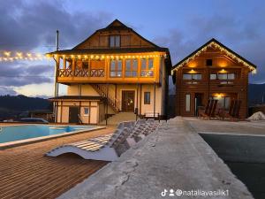 a house with a pool in front of it at Байка Карпат in Vorokhta
