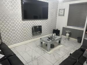 a living room with a table and a tv on the wall at Beautiful 1-Bed House in Bradford in Bradford