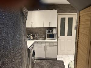 una pequeña cocina con armarios blancos y microondas en Beautiful 1-Bed House in Bradford, en Bradford