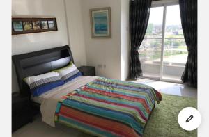 a bedroom with a large bed and a large window at Gallery Apartments by BestWest Hospitality in Accra