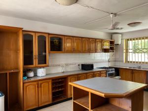 a kitchen with wooden cabinets and a table in it at Bambi Smart Homes in Otinshi