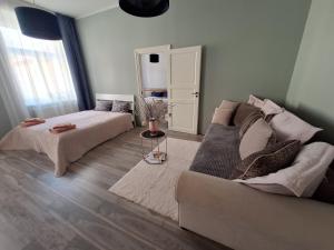 uma sala de estar com um sofá e uma cama em AMMENDE em Cēsis